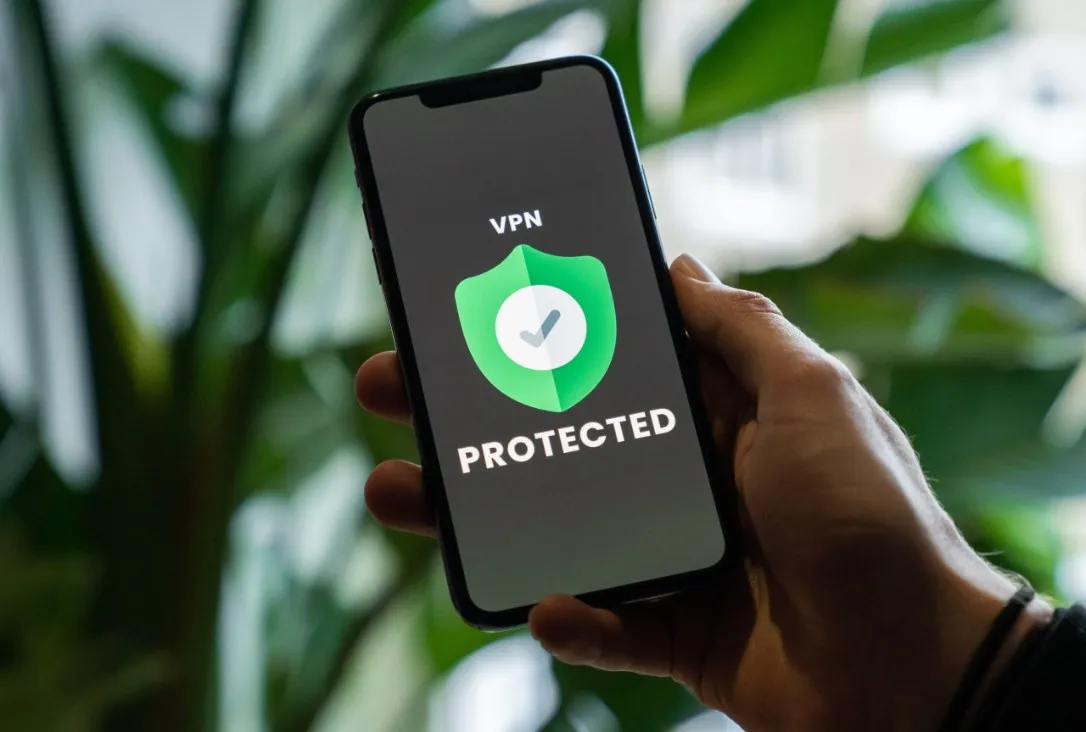 Person holding up cell phone with a VPN Protected logo showing
